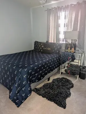 a bedroom with a bed and a table with a couch at The Love Home Stay in Edmonton
