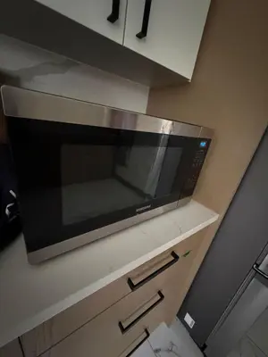 a microwave sitting on top of a kitchen cabinet at Downtown Vancouver Rooms - Walk to SkyTrain & BC Place, Free Parking & Fast Wi-Fi in Vancouver