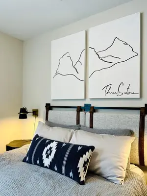 a bedroom with a bed with a picture on the wall at Pet-friendly Walk-Up Condo with Pool & Hot tub! in Canmore