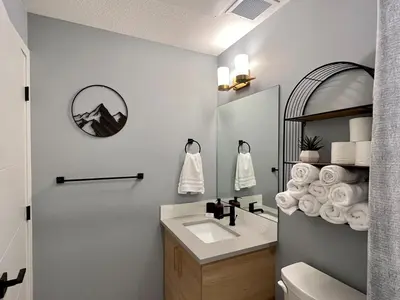 a bathroom with a sink and a mirror at Pet-friendly Walk-Up Condo with Pool & Hot tub! in Canmore