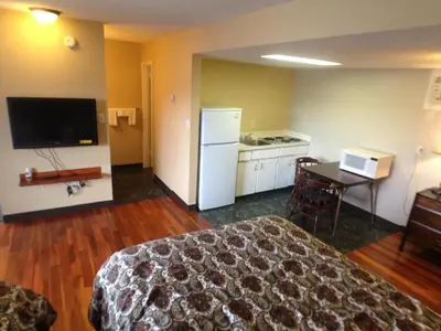 a hotel room with a bed and a desk and a kitchen at Galaxy Motel in St. Paul