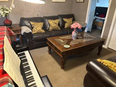 a living room with a couch and a table with a piano at Sweet Home in Aldergrove