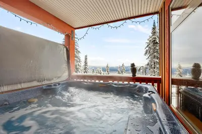 a hot tub in a room with a window at Blackrock 6 in Big White