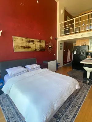 a bedroom with a white bed and a red wall at 933 seymour at vancouver downtown in Vancouver