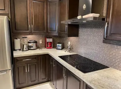 a kitchen with wooden cabinets and a stove top oven at Vancouver Burnaby Villa 44 in Burnaby