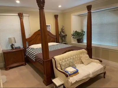 a bedroom with a canopy bed and a couch at Vancouver Burnaby Villa 44 in Burnaby