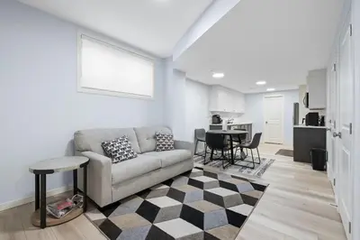 a living room with a couch and a table at Cozy 2 Bedroom Private Basement Suite SW Calgary in Calgary