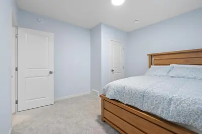 a white bedroom with a bed and a closet at Cozy 2 Bedroom Private Basement Suite SW Calgary in Calgary