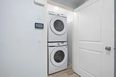 a white laundry room with a washer and dryer at Cozy 2 Bedroom Private Basement Suite SW Calgary in Calgary