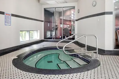a swimming pool in a building with ailed floor at Modern Central Location with Pool Sauna & Jacuzzi in Vancouver