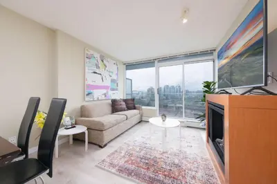 a living room with a couch and a tv at Modern Central Location with Pool Sauna & Jacuzzi in Vancouver