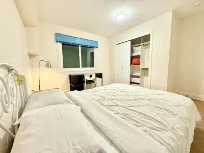 a white bed in a room with a window at Private Guest Suite, Two Parking Spaces in Maple Ridge District Municipality