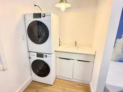 a laundry room with a washer and dryer next to a sink at Private Guest Suite, One Parking Space in Maple Ridge District Municipality