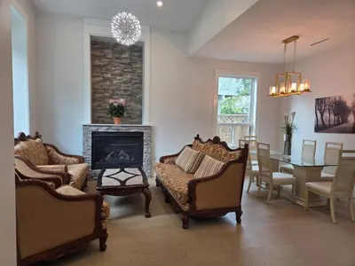 a living room with chairs and a fireplace and a table at Luxury Suite in New Villa in Surrey
