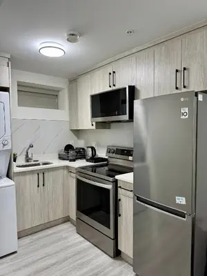 a kitchen with stainless steel appliances and wooden cabinets at Comfort 2 BR Vancouver! in Vancouver