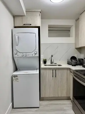 a kitchen with a white refrigerator and a sink at Comfort 2 BR Vancouver! in Vancouver