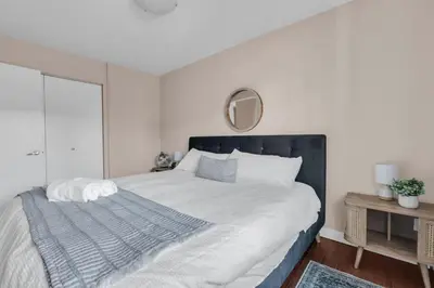 a bedroom with a large bed and a mirror at 2B 17 Ave King Suite in Calgary