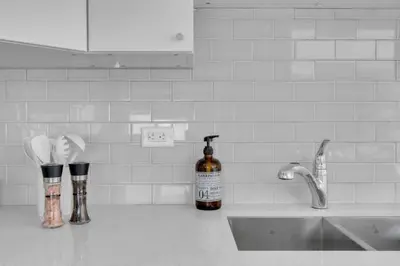 a bottle of alcohol sitting on a kitchen counter next to a sink at 2B 17 Ave King Suite in Calgary