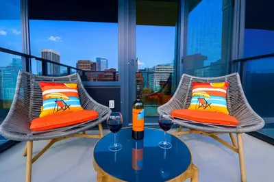two chairs and a table with wine glasses on a balcony at 1506 First and Park in Calgary
