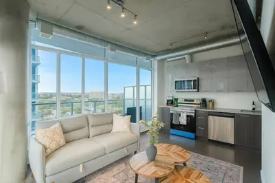 a living room with a couch and a table at Cozy Downtown Retreat with Stunning River Views in Calgary