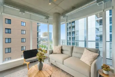 a living room with a couch and large windows at Cozy Downtown Retreat with Stunning River Views in Calgary