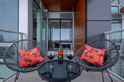 a glass table with two glasses of wine on a balcony at 418 Frontier in Calgary