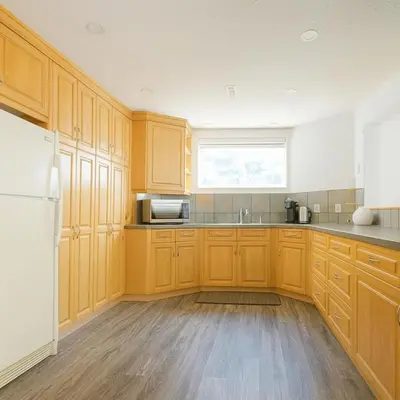 a kitchen with wooden cabinets and a window at Shiraz Place in Calgary