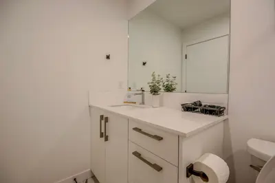 a white bathroom with a sink and a mirror at 431 Frontier in Calgary