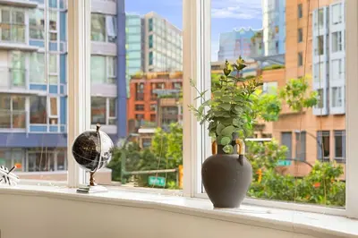 a vase sitting on a window sill with a plant at Stylish 2BR Downtown Condo By Arena Free Parking in Vancouver
