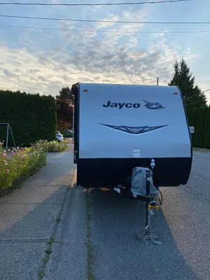 a large truck is parked on the side of a road at Warm new Jayco trailer with comfy queen bed in Aldergrove