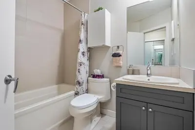 a bathroom with a toilet and a sink and a tub at Entire Home - 2 Separate Units in Calgary