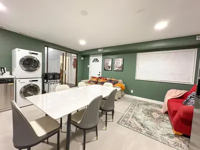 a dining room with a white table and a living room at Vancouver UBC 3BD Garden Suite in Vancouver