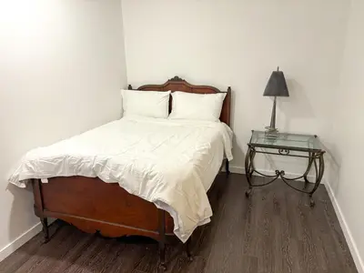 a bedroom with a bed and a table with a lamp at Vancouver UBC 3BD Garden Suite in Vancouver