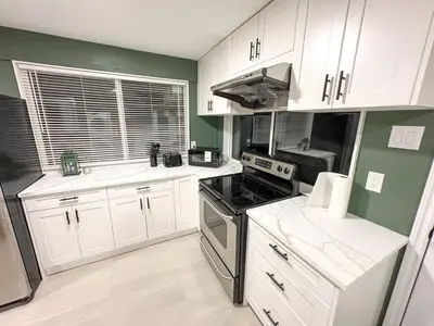 a kitchen with white cabinets and a stove top oven at Vancouver UBC 3BD Garden Suite in Vancouver