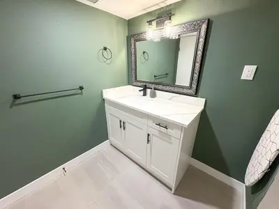 a bathroom with a white sink and a mirror at Vancouver UBC 3BD Garden Suite in Vancouver