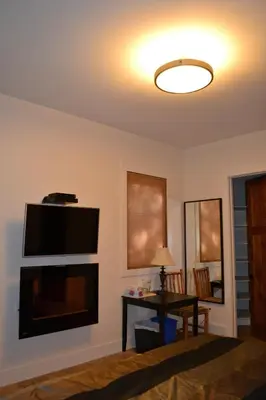a living room with a flat screen tv and a table at Radium Elk Park B & B in Radium Hot Springs