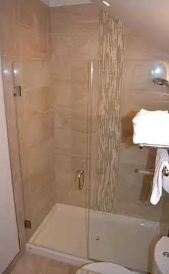 a shower with a glass door in a bathroom at Radium Elk Park B & B in Radium Hot Springs