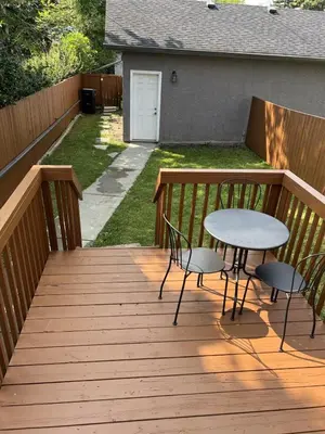 a wooden deck with a table and chairs on it at Modern 2 BR Vacation Home Near West Edmonton Mall in Edmonton
