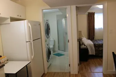 a kitchen with a refrigerator and a bathroom with a shower at Modern 2 BR Vacation Home Near West Edmonton Mall in Edmonton