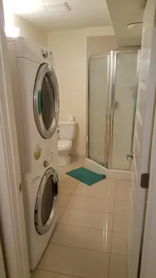 a bathroom with a washing machine and a toilet at Modern 2 BR Vacation Home Near West Edmonton Mall in Edmonton