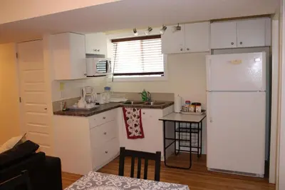 a kitchen with white cabinets and a white refrigerator at Modern 2 BR Vacation Home Near West Edmonton Mall in Edmonton