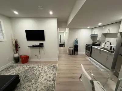 a living room with a television and a kitchen at The ideal place for professionals in Prince George