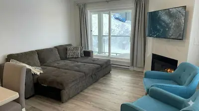 a living room with a couch and a fireplace at True Ski-In-Ski-Out Rare 3-Bed Condo in Mount Washington