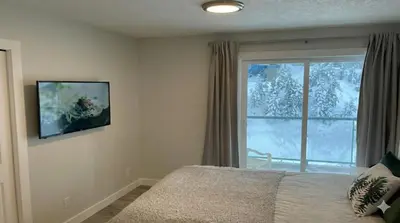 a bedroom with a bed and a window with snow at True Ski-In-Ski-Out Rare 3-Bed Condo in Mount Washington