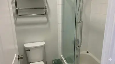 a bathroom with a toilet and a glass shower at True Ski-In-Ski-Out Rare 3-Bed Condo in Mount Washington