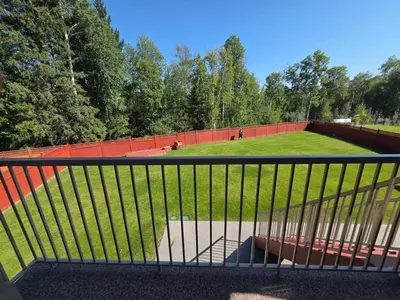 a view of a park with a fence and a field at Modern 2 Bedroom Suite Private & Fully Furnished in Prince George