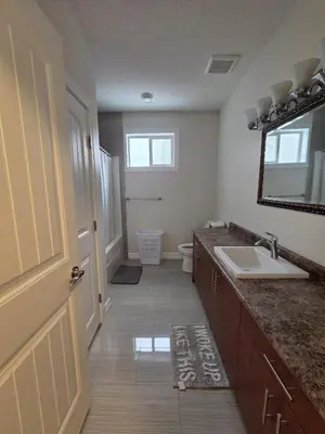 a bathroom with a sink and a toilet and a mirror at Modern 2 Bedroom Suite Private & Fully Furnished in Prince George