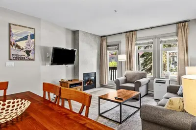 a living room with a couch and a fireplace at Cedar and Stone - 2 Bed 2 Bath Condo with Heated Pool and Hot Tub in Canmore
