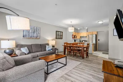 a living room with a couch and a table at Cedar and Stone - 2 Bed 2 Bath Condo with Heated Pool and Hot Tub in Canmore