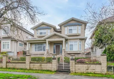a house with a fence in front of it at Cozy Room with Private Washroom in Central Location in Vancouver